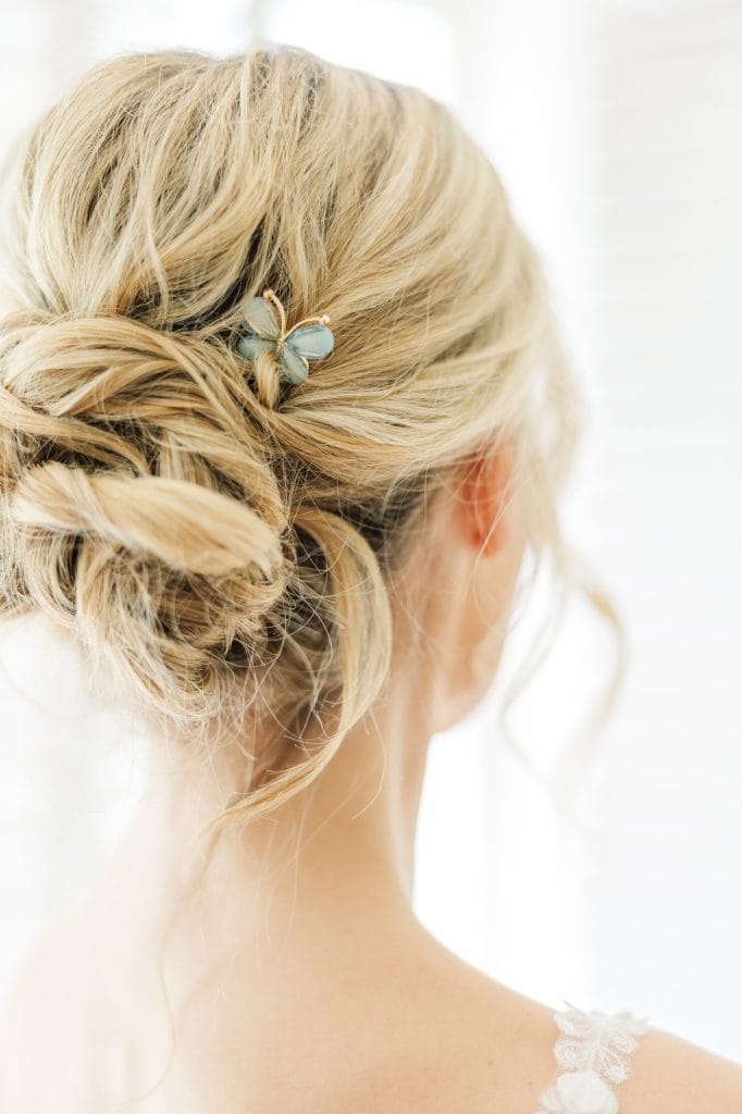 Elegant bride with hair styled in a sophisticated bun with a butterfly pin